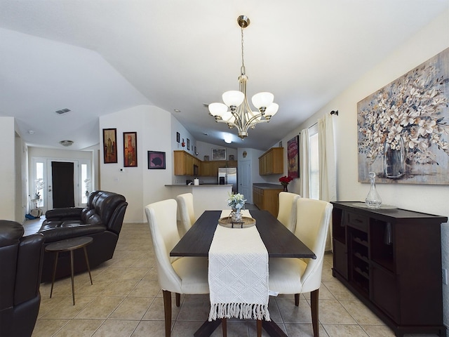 dining area with visible vents, vaulted ceiling, a notable chandelier, and light tile patterned flooring