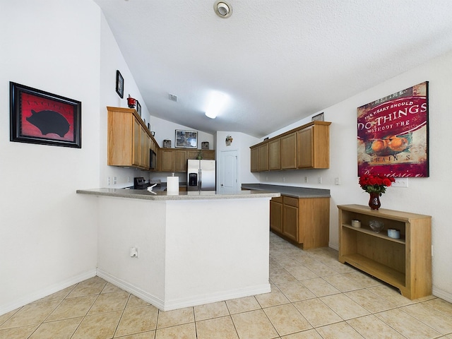 kitchen with lofted ceiling, stainless steel refrigerator with ice dispenser, a peninsula, and light tile patterned floors