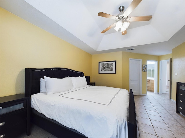 bedroom with a tray ceiling, visible vents, a ceiling fan, light tile patterned flooring, and baseboards