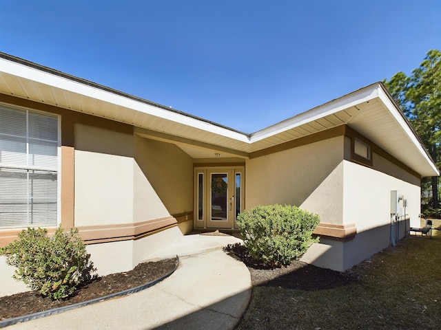 view of exterior entry featuring stucco siding