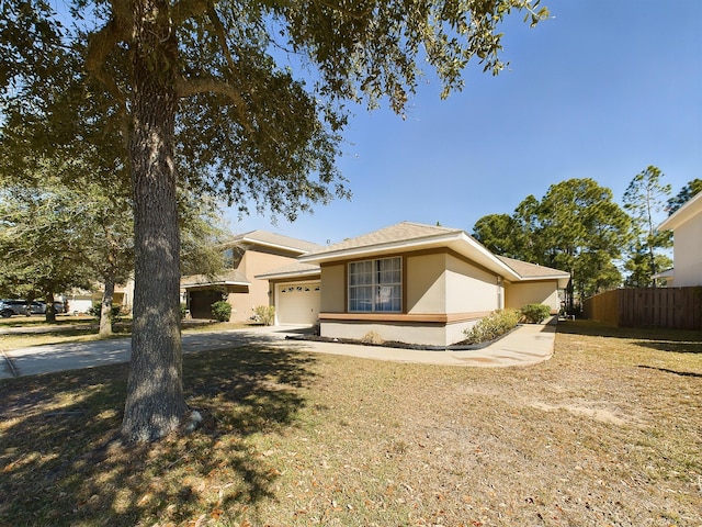 view of front of home with an attached garage, fence, concrete driveway, and stucco siding