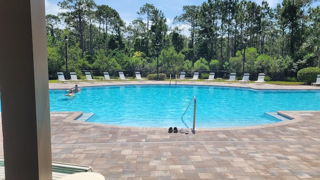 community pool featuring a patio area and fence