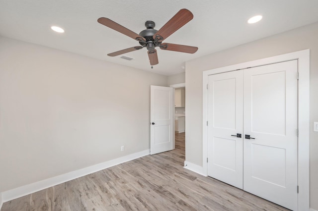 unfurnished bedroom featuring light hardwood / wood-style flooring, a closet, and ceiling fan