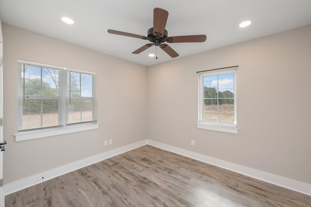 spare room with hardwood / wood-style flooring, a wealth of natural light, and ceiling fan