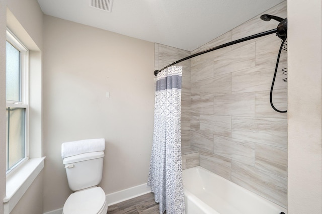 bathroom featuring hardwood / wood-style flooring, shower / bath combination with curtain, and toilet