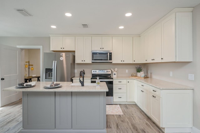 kitchen featuring light stone counters, stainless steel appliances, and a kitchen island