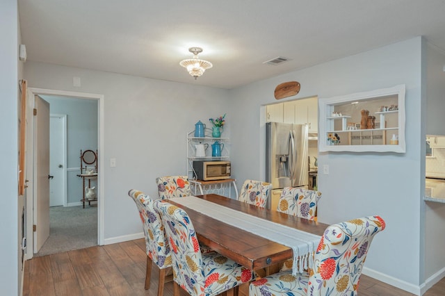 dining area with dark hardwood / wood-style flooring