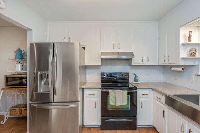 kitchen featuring decorative backsplash, light hardwood / wood-style floors, white cabinets, and appliances with stainless steel finishes