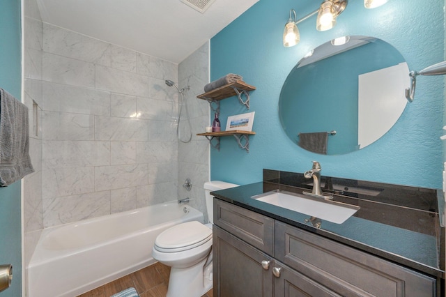 full bathroom with vanity, hardwood / wood-style floors, tiled shower / bath combo, and toilet