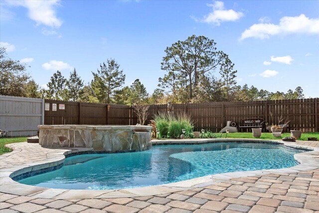 view of pool featuring pool water feature and a patio