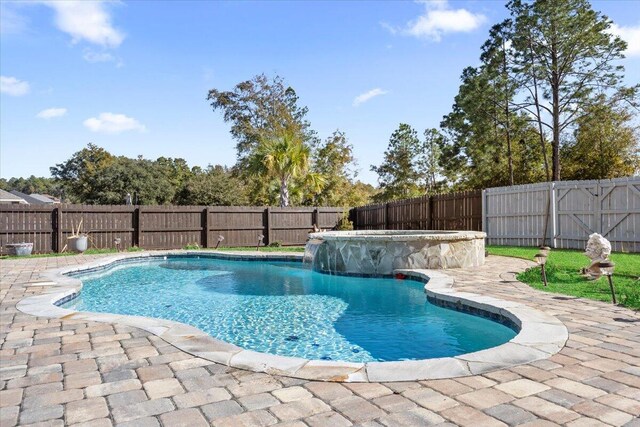 view of swimming pool featuring pool water feature and a patio