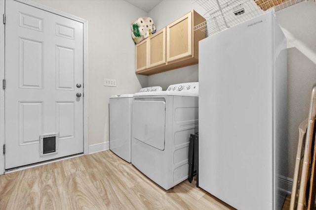 laundry room featuring cabinets, separate washer and dryer, and light wood-type flooring