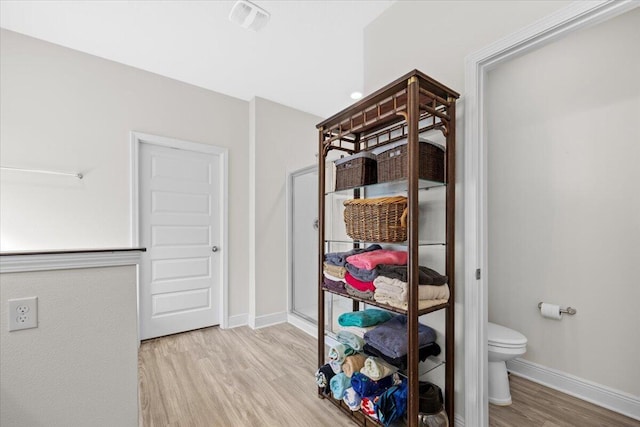 interior space with toilet and hardwood / wood-style floors