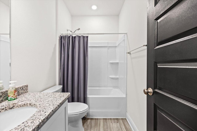 full bathroom with hardwood / wood-style flooring, shower / bath combo, vanity, and toilet