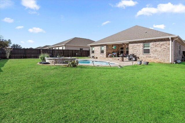 back of property featuring a yard, a fenced in pool, and a patio