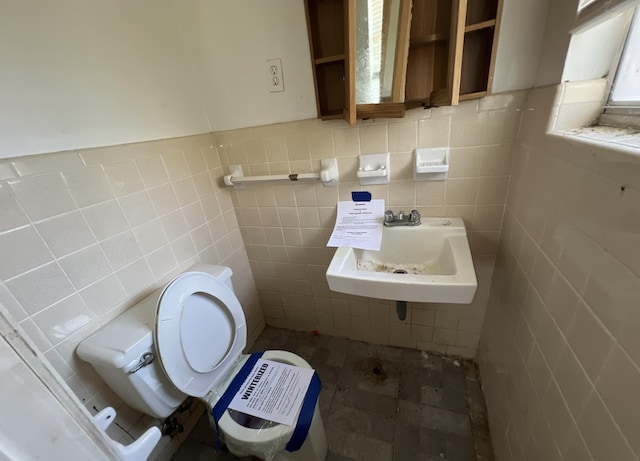 bathroom featuring tile walls, sink, and toilet