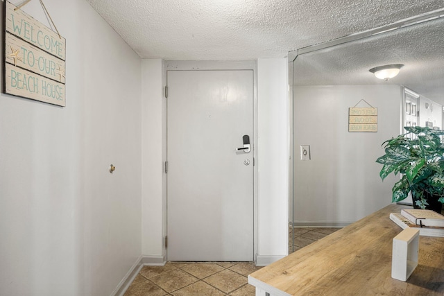 corridor with light tile patterned floors and a textured ceiling