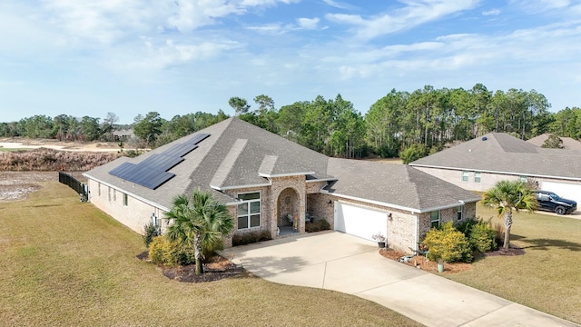 view of front of home featuring a front lawn, solar panels, and a garage