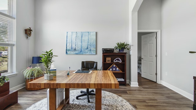 office with dark hardwood / wood-style flooring