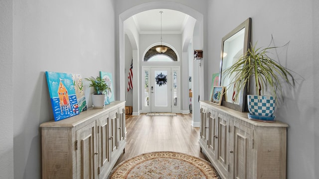 entryway featuring crown molding and light hardwood / wood-style floors