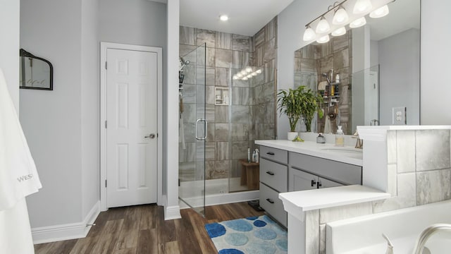 bathroom featuring hardwood / wood-style flooring, walk in shower, and vanity