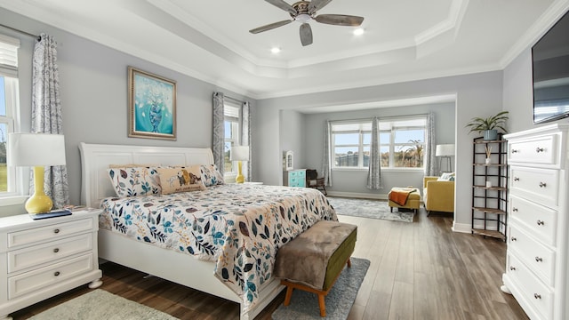 bedroom with a raised ceiling, ceiling fan, crown molding, and dark hardwood / wood-style floors