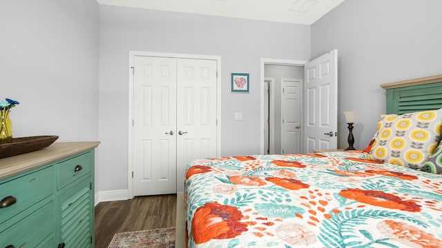 bedroom with dark hardwood / wood-style floors and a closet