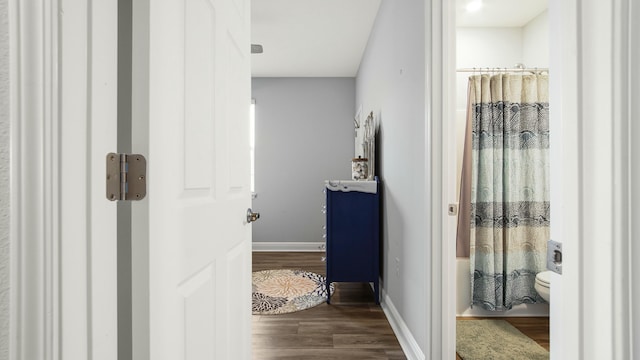 bathroom featuring hardwood / wood-style floors, toilet, and shower / bath combination with curtain