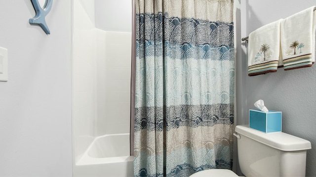 bathroom featuring shower / tub combo with curtain and toilet