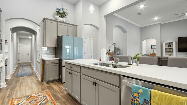 kitchen featuring stainless steel dishwasher, sink, gray cabinetry, and hardwood / wood-style flooring