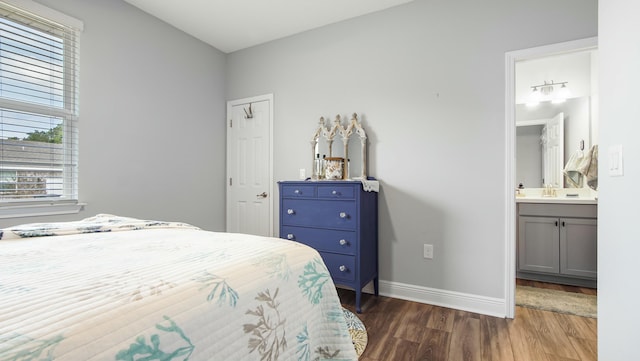 bedroom featuring ensuite bath and dark hardwood / wood-style flooring