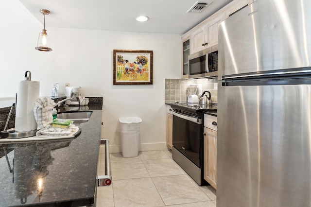 kitchen featuring pendant lighting, sink, appliances with stainless steel finishes, dark stone countertops, and backsplash