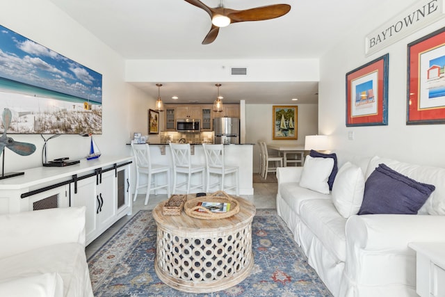 living room with dark tile patterned floors and ceiling fan