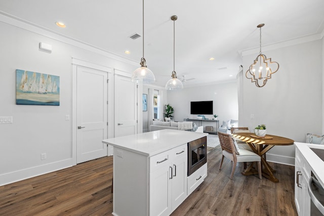 83 Sawgrass Ln, Santa Rosa Beach, FL 32459 - kitchen with hanging light fixtures, ornamental molding, appliances with stainless steel finishes, dark hardwood / wood-style flooring, and white cabinets