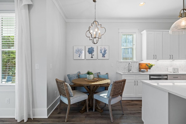 83 Sawgrass Ln, Santa Rosa Beach, FL 32459 - dining space featuring dark wood-type flooring, an inviting chandelier, crown molding, and sink