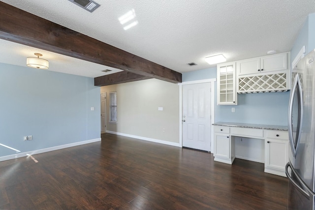 kitchen featuring visible vents, glass insert cabinets, dark wood-style flooring, freestanding refrigerator, and white cabinetry