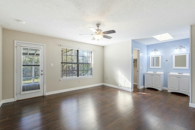 interior space featuring dark wood-style floors, a skylight, and a textured ceiling