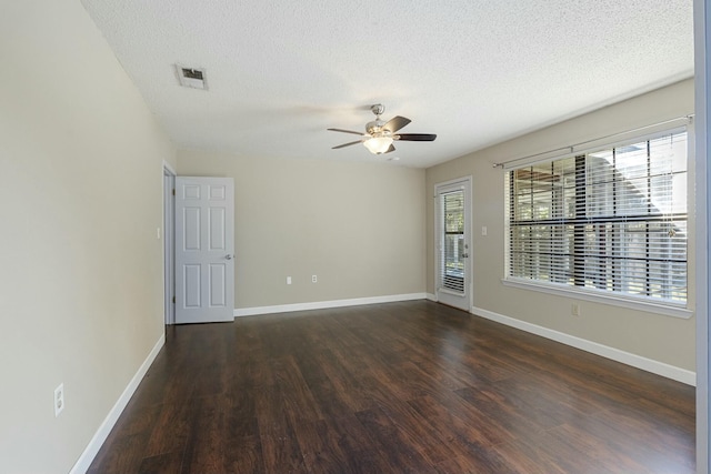 unfurnished room with baseboards, visible vents, a ceiling fan, dark wood-style flooring, and a textured ceiling