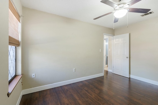 spare room featuring baseboards, visible vents, ceiling fan, and wood finished floors