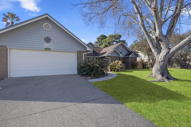 single story home with a garage, a front yard, aphalt driveway, and brick siding