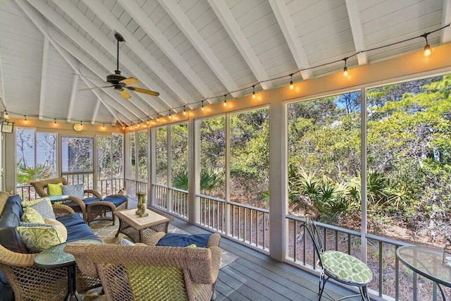 sunroom featuring vaulted ceiling with beams and ceiling fan