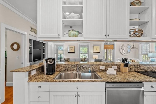 kitchen with stainless steel dishwasher, dark stone counters, sink, and white cabinets