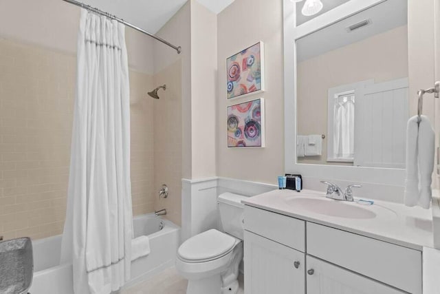 full bathroom with shower / tub combo with curtain, vanity, and toilet