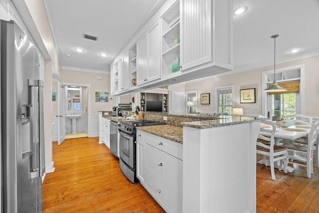 kitchen with white cabinetry, hanging light fixtures, dark stone countertops, stainless steel appliances, and kitchen peninsula