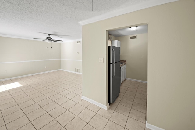 unfurnished room featuring a ceiling fan, visible vents, a textured ceiling, and light tile patterned floors