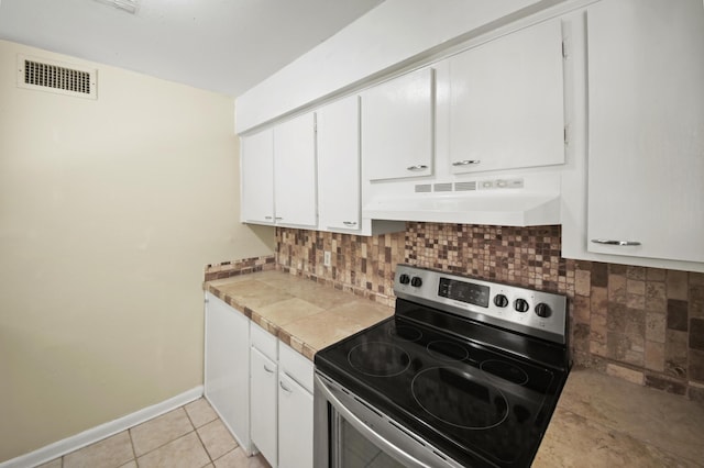 kitchen featuring stainless steel electric stove, light countertops, visible vents, white cabinetry, and under cabinet range hood