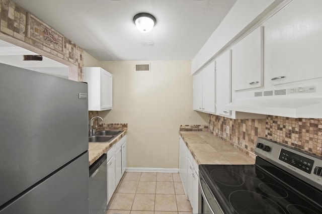 kitchen with white cabinets, appliances with stainless steel finishes, light countertops, under cabinet range hood, and a sink