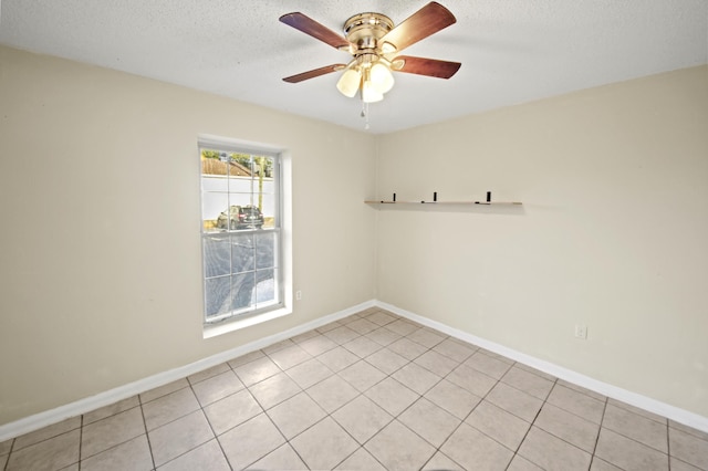 spare room with a textured ceiling, baseboards, and a ceiling fan