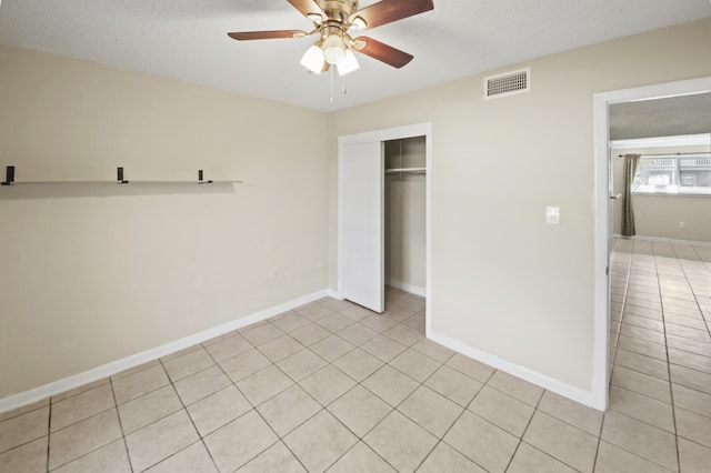 unfurnished bedroom with a closet, visible vents, baseboards, and light tile patterned floors