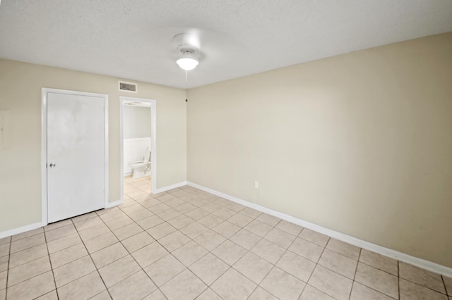 empty room with a textured ceiling, visible vents, and baseboards